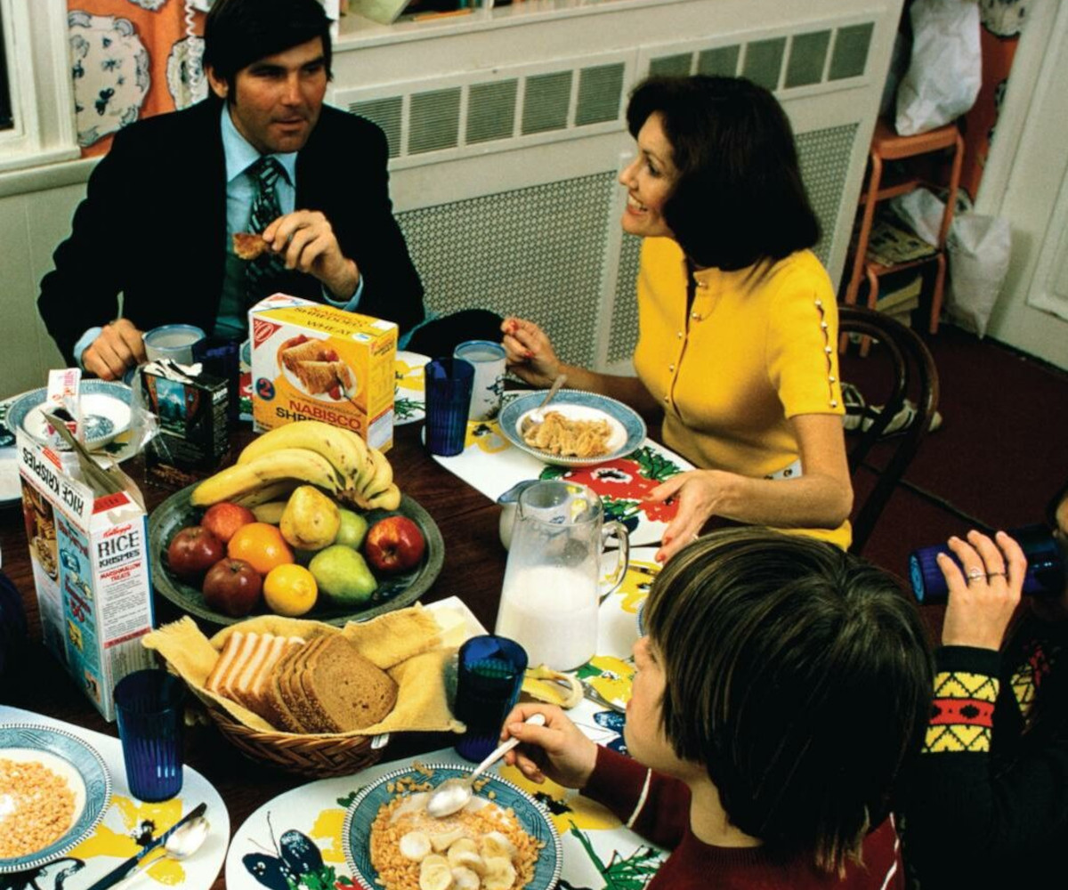 Old photo of a family sat around a dinner table for breakfast (likely 1970s/80s)