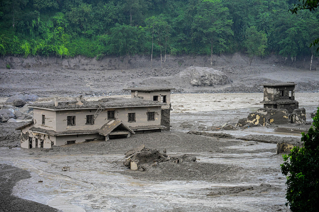 A building sits submerged in debris and mud