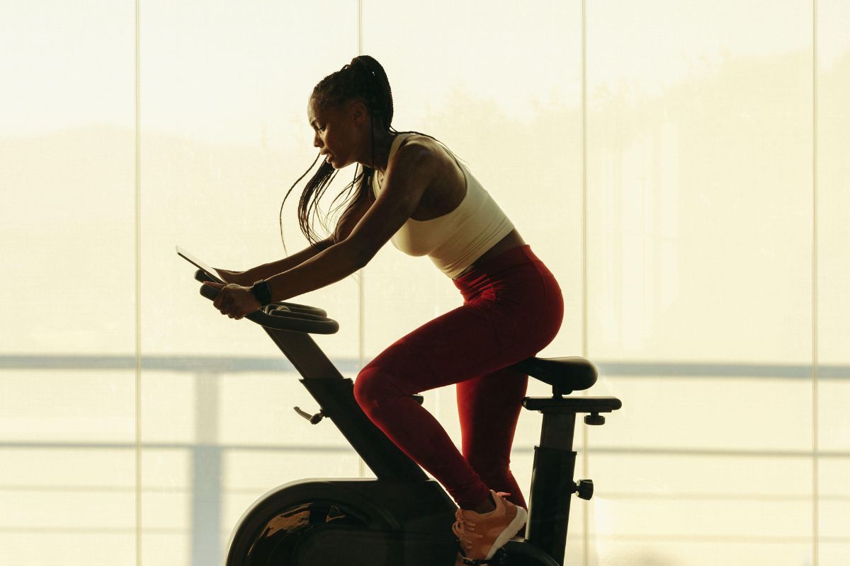 A woman uses a cycling machine at the gym