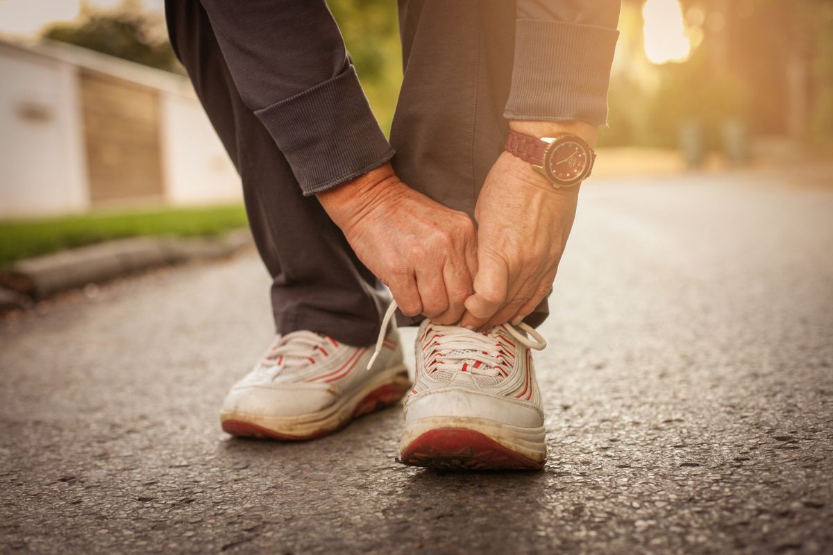 An older woman ties her running shoes