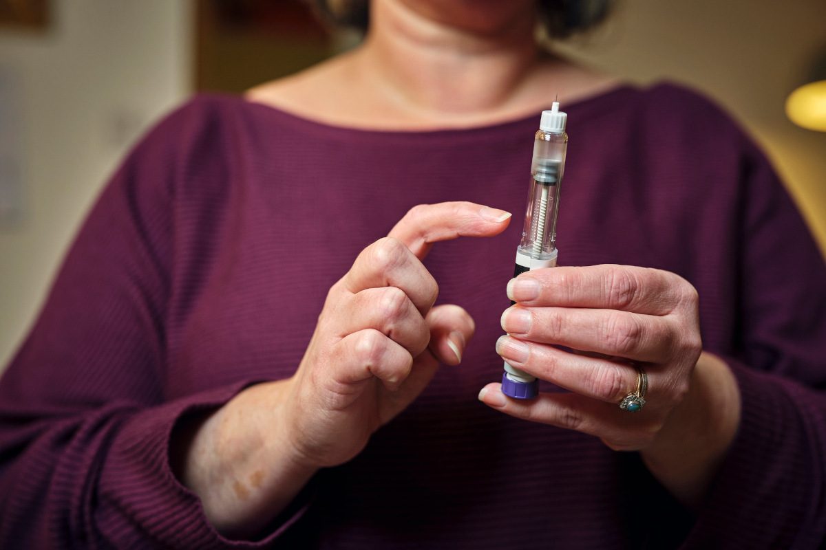 A woman prepares for a subcutaneous self-injection with a semaglutide pen