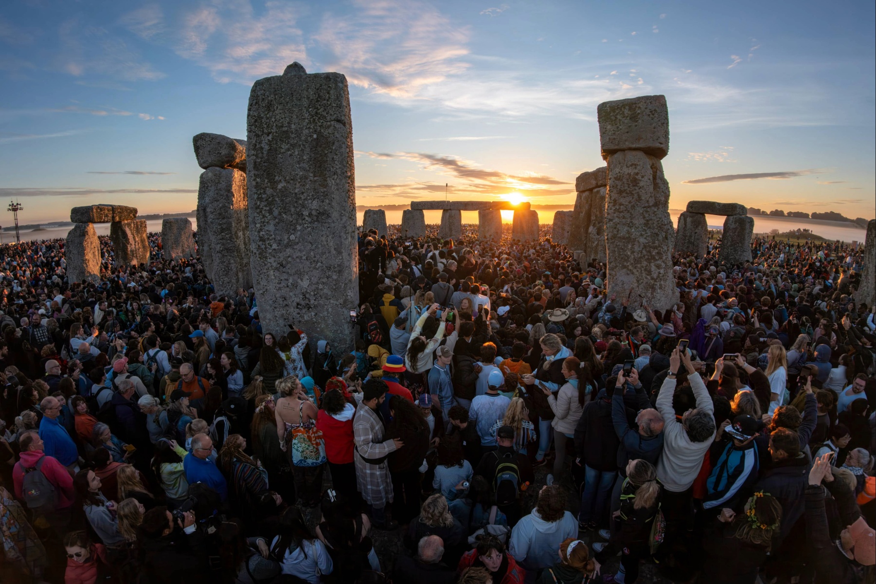Large crowd gathered around Stonehenge at sunrise