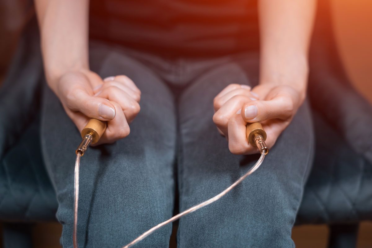 Two hands holding electrodes.