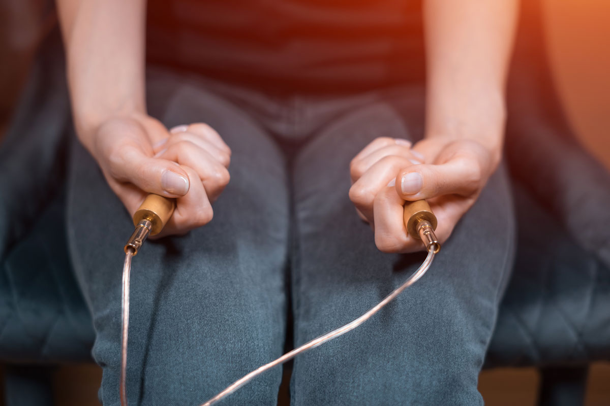 Two hands holding electrodes.
