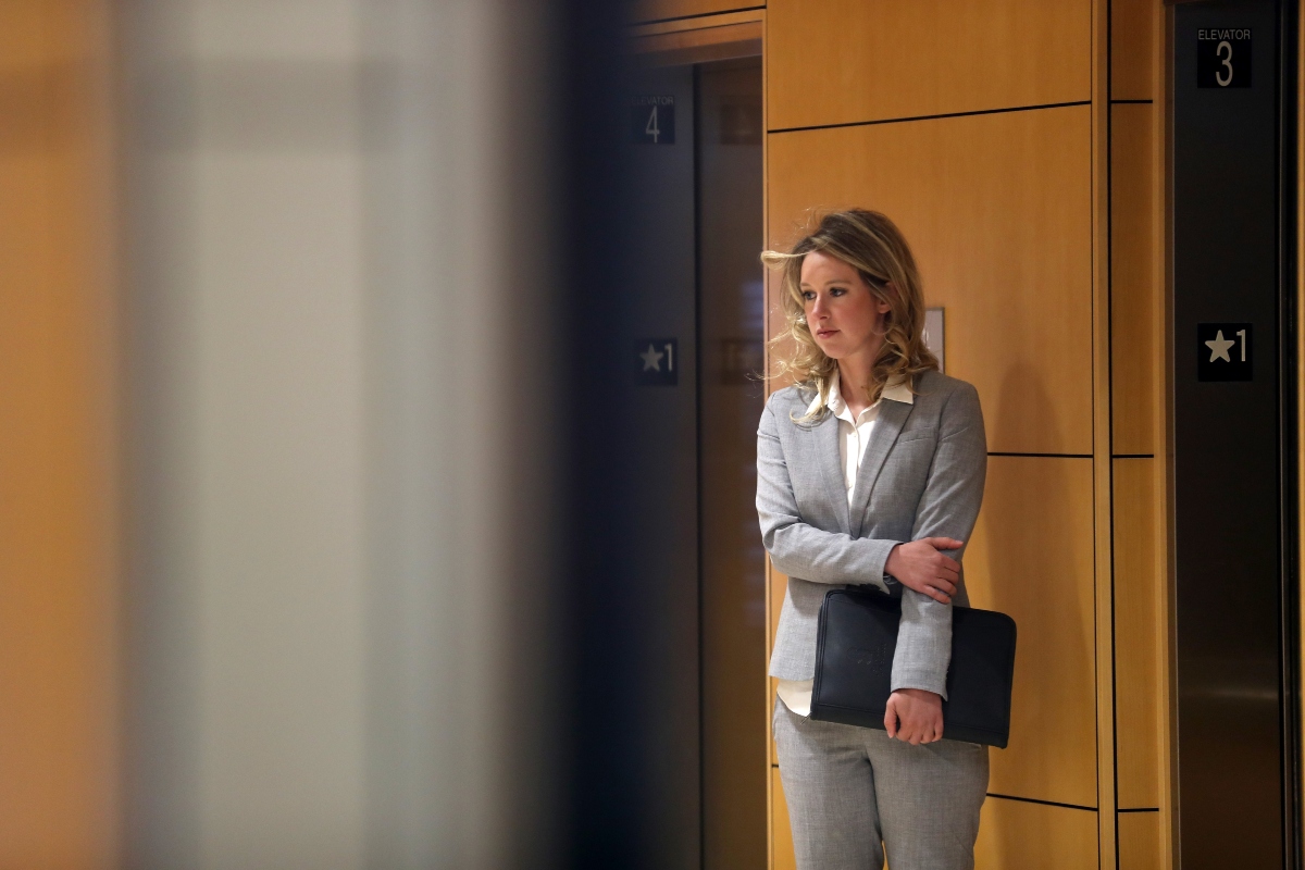 A medium shot of Elizabeth Holmes in a grey suit looking nervous