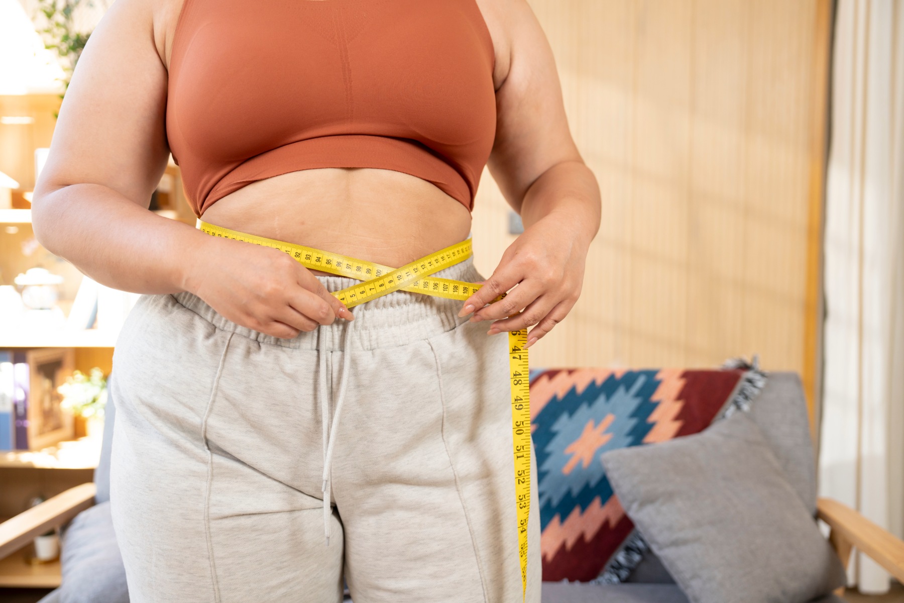 Woman measuring her waistline