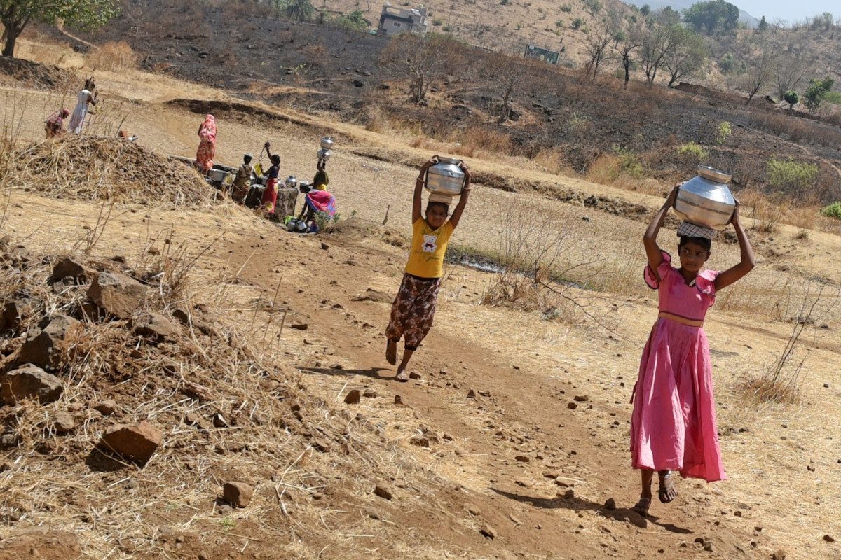 Villagers are carrying pots filled with water after drawing it from a well during the heatwave India, 2024