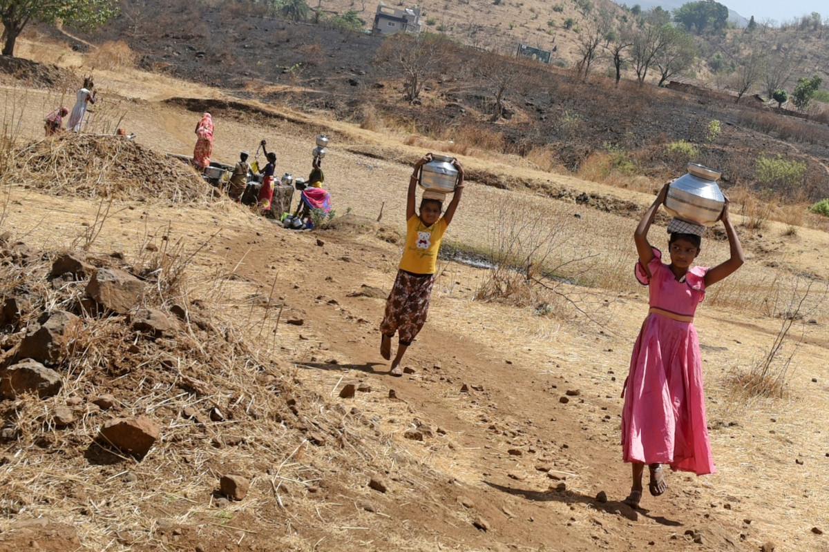 Villagers are carrying pots filled with water after drawing it from a well during the heatwave India, 2024