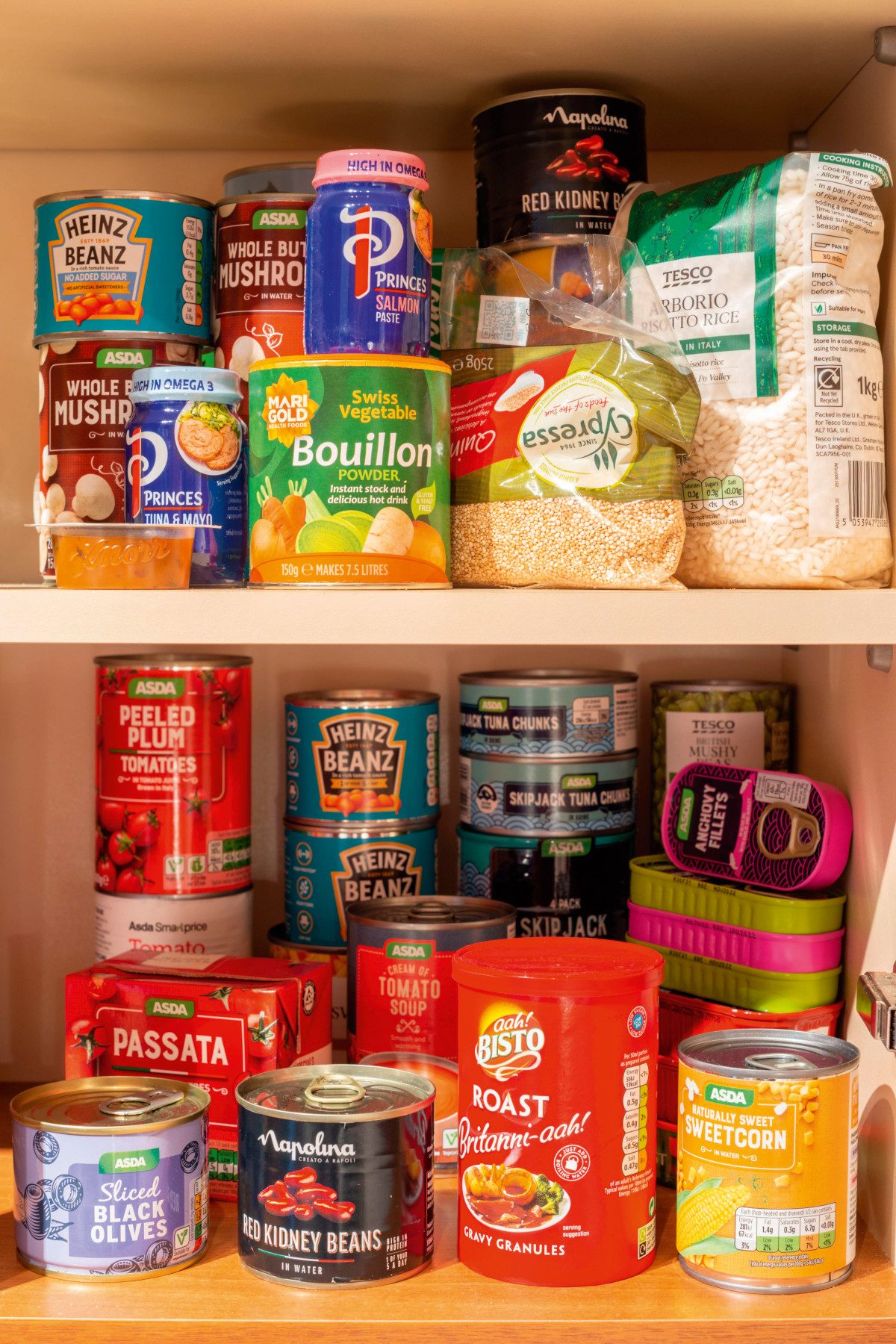 An assortment of tinned and dried foodstuffs on two shelves