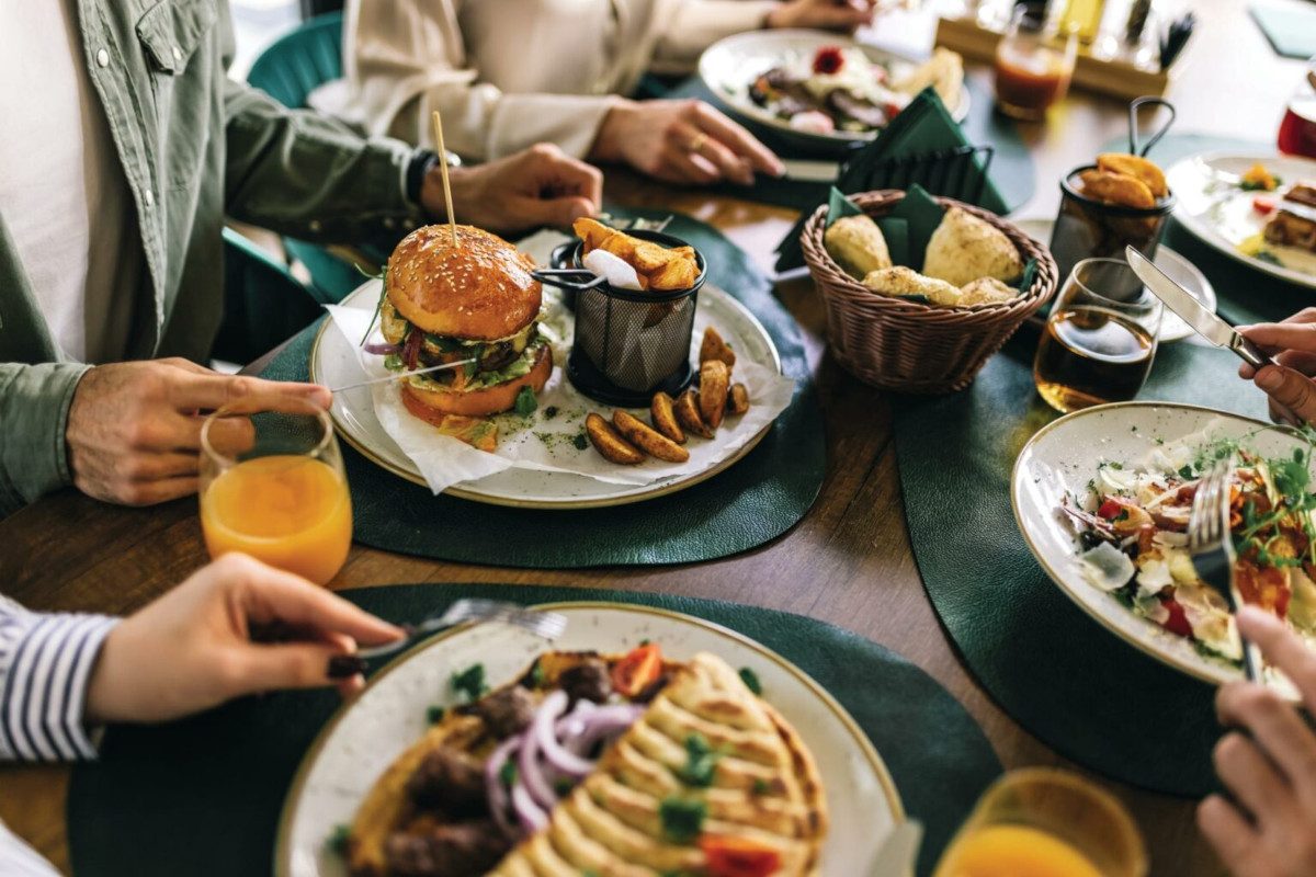 Photo of a group of people at a restaurant with different meals