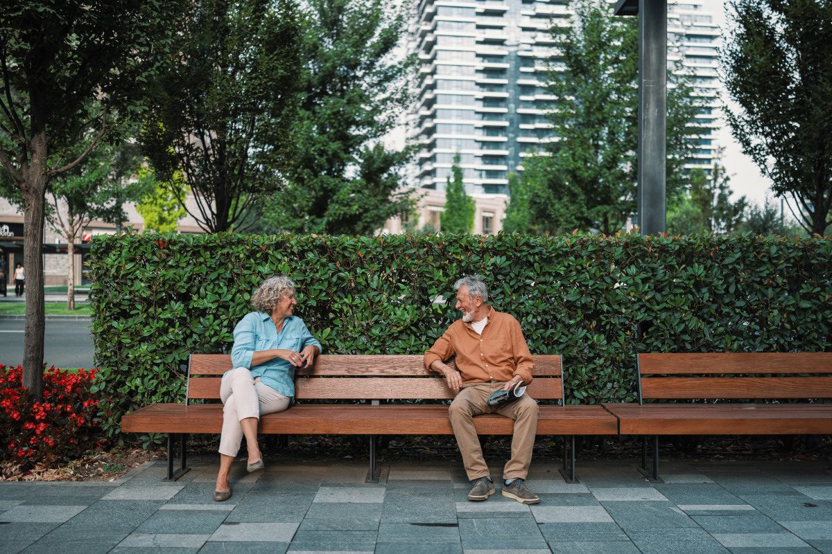 Strangers starting conversation on park bench
