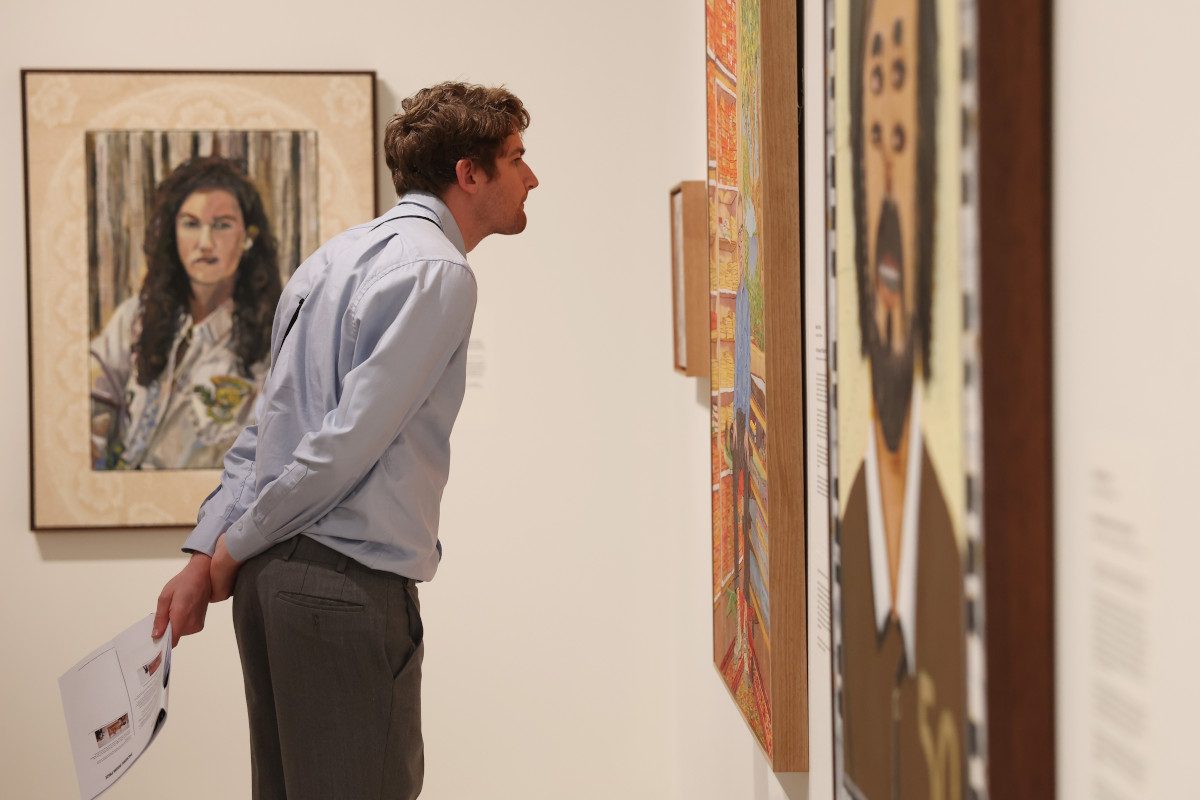 A person inspects art in a gallery