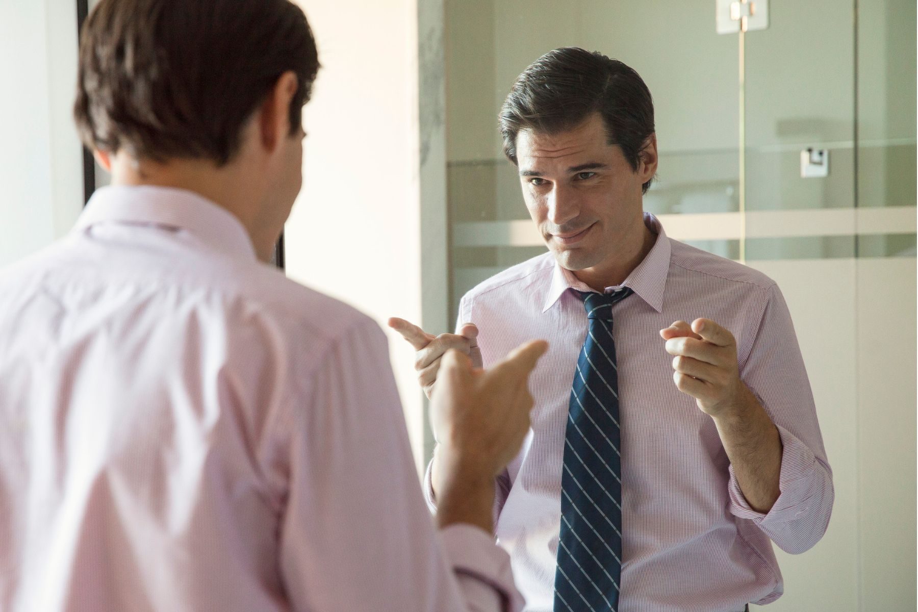 A man points at his own reflection in a mirror