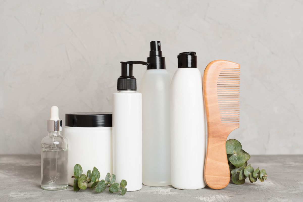 Professional hair care products with comb on table