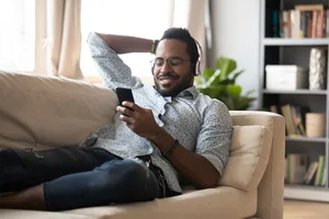 Best science audiobooks © Getty Images Man reclining on sofa, listening to something on headphones © Getty Images