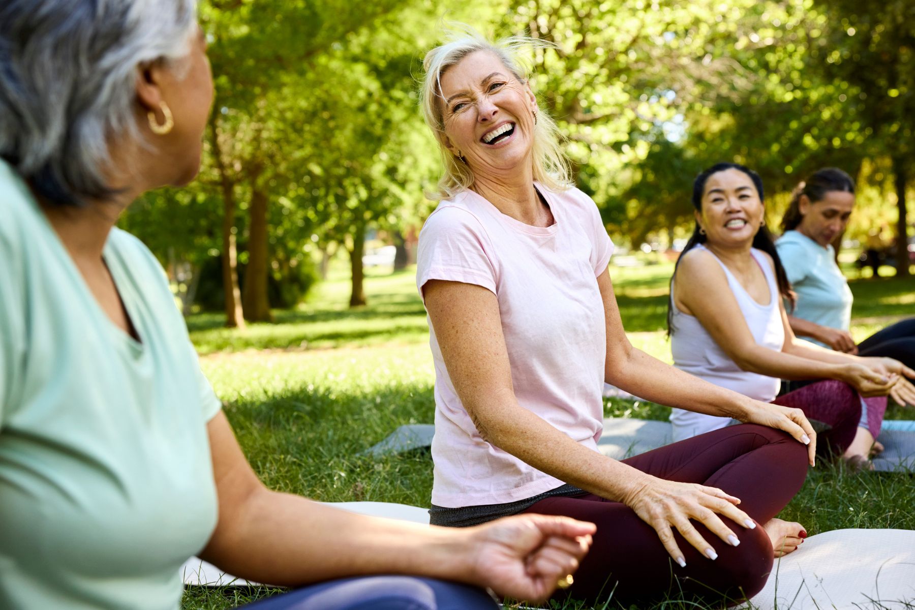 Women sit in a park in workout clothes