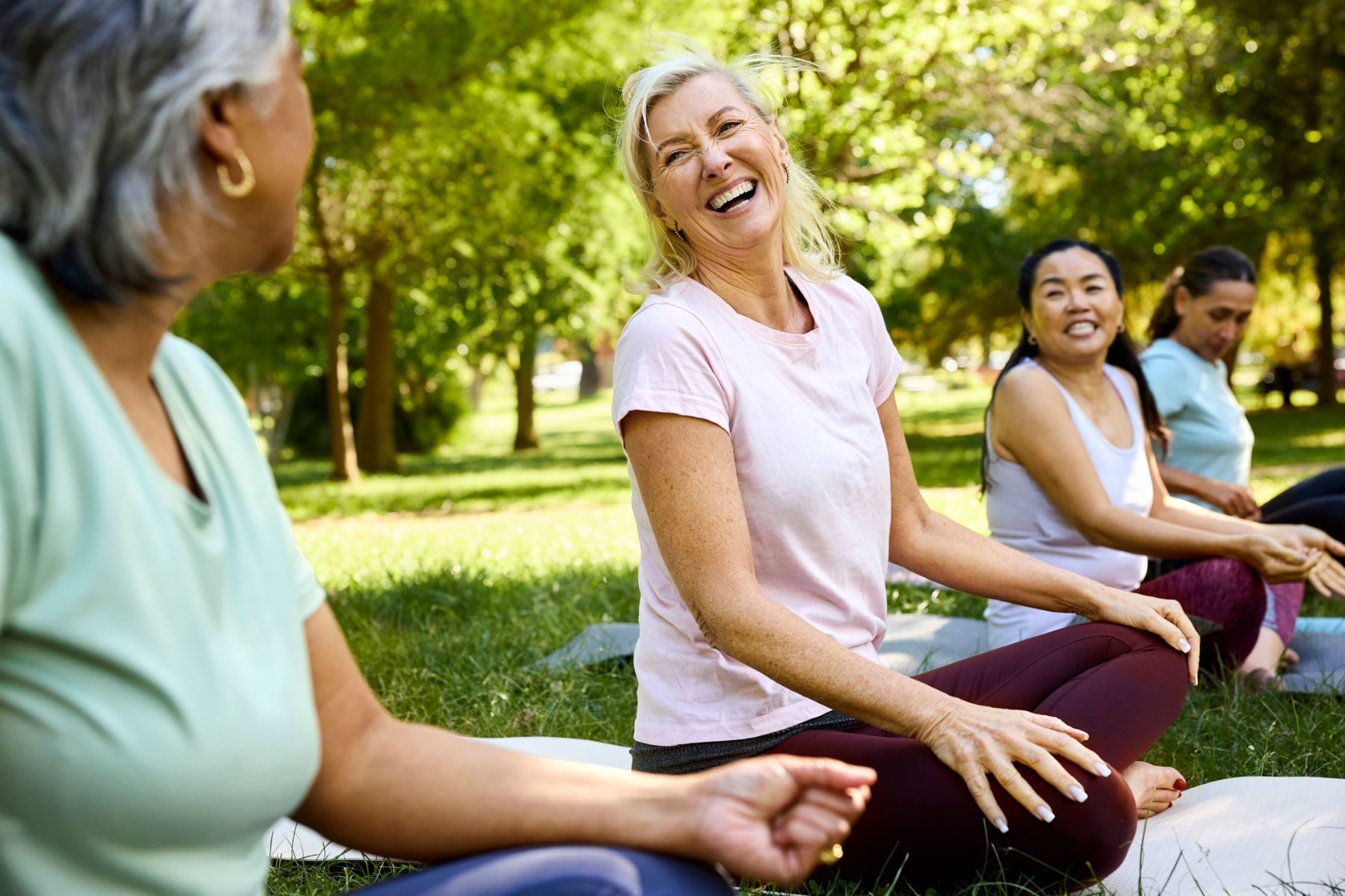 Women sit in a park in workout clothes