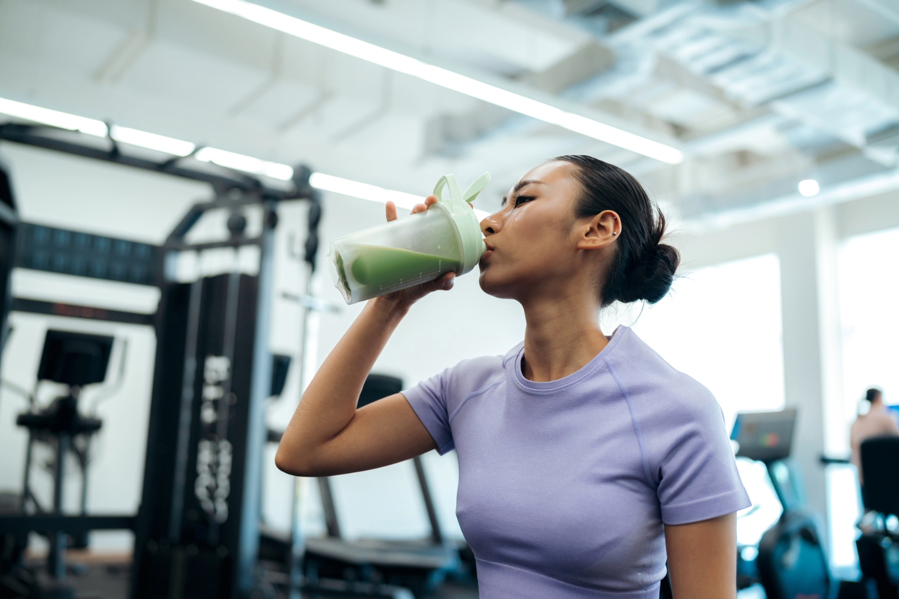 Young woman in the gym drinking a protein shake