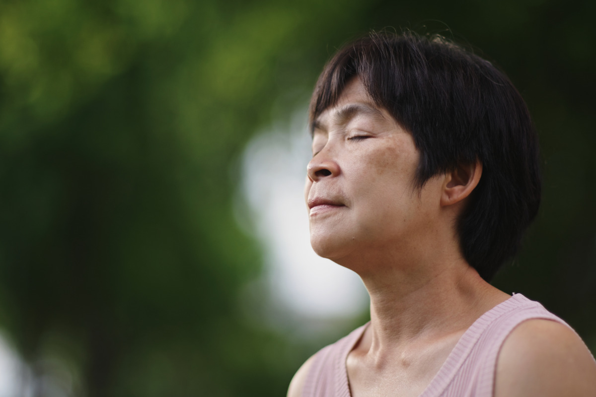 Close up of a person with their eyes closed, breathing slowly through their nose