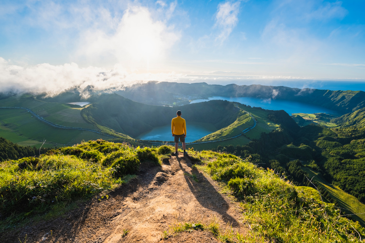 Man on top of a mountain admiring Lagoa das Sete Cidades, Azores