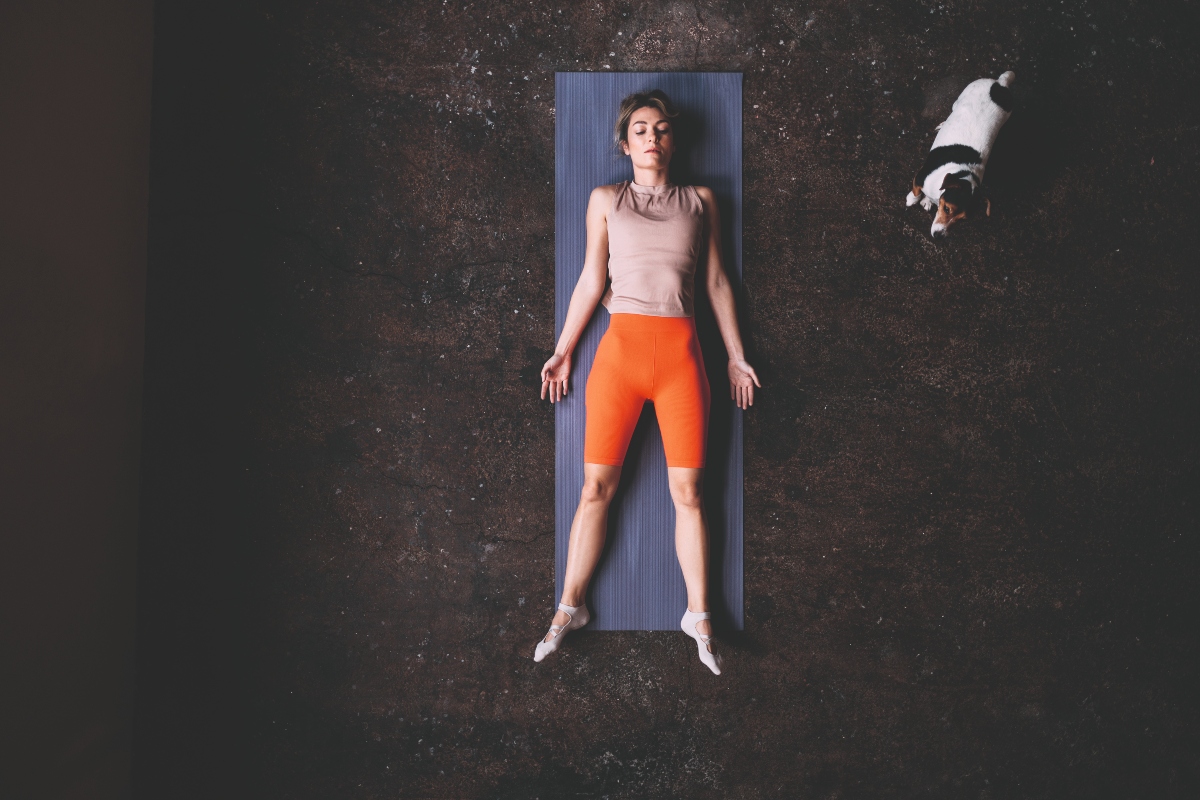 Woman lying down on a yoga mat trying to relax