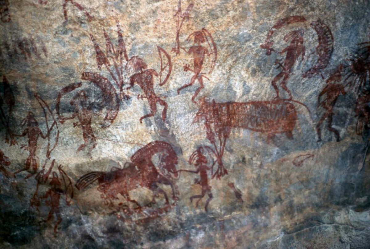 Photo of the Bhimbetka Cave paintings, which shows people hunting animals with bows and arrows