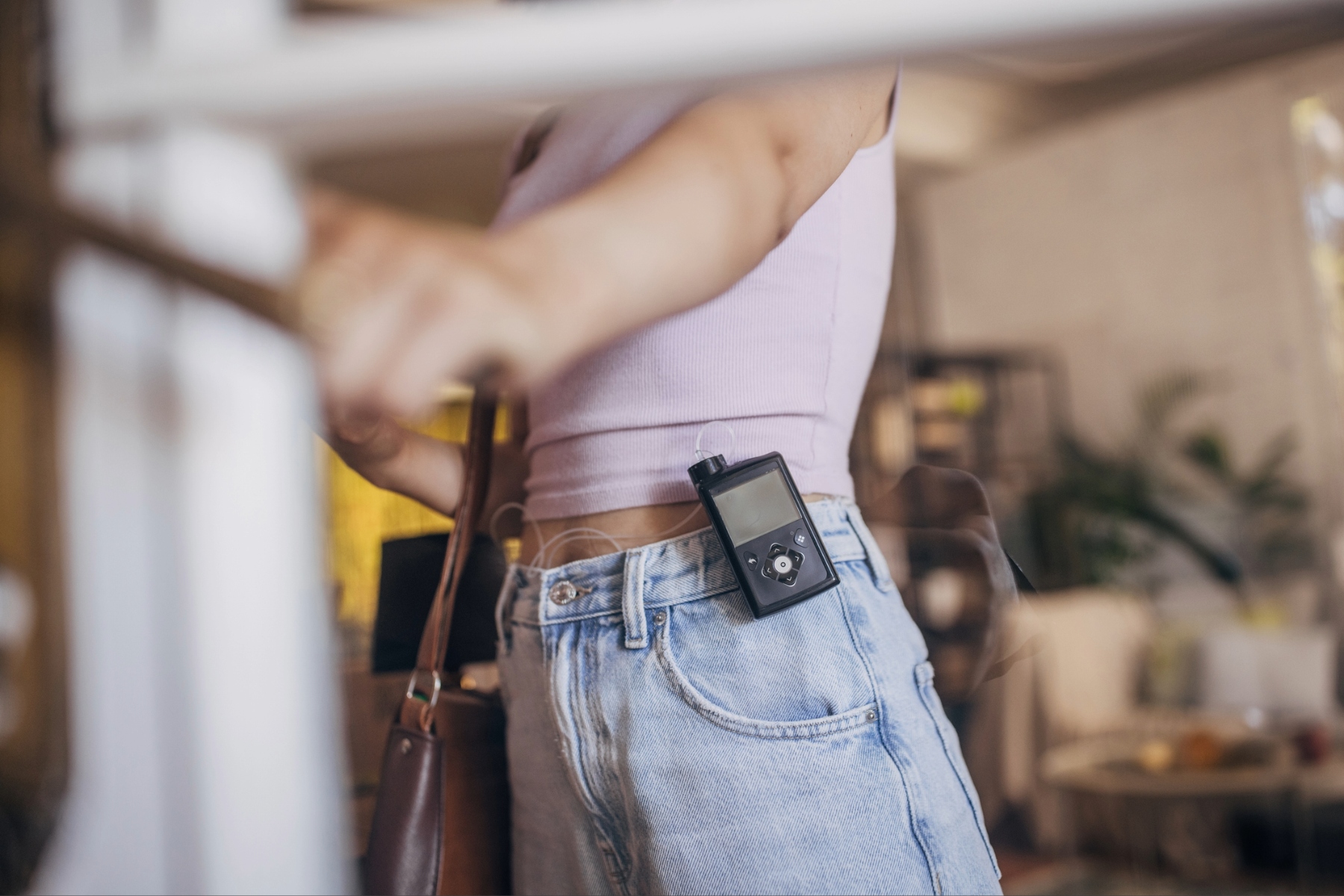 Insulin pump attached to the waistband of a woman's jeans