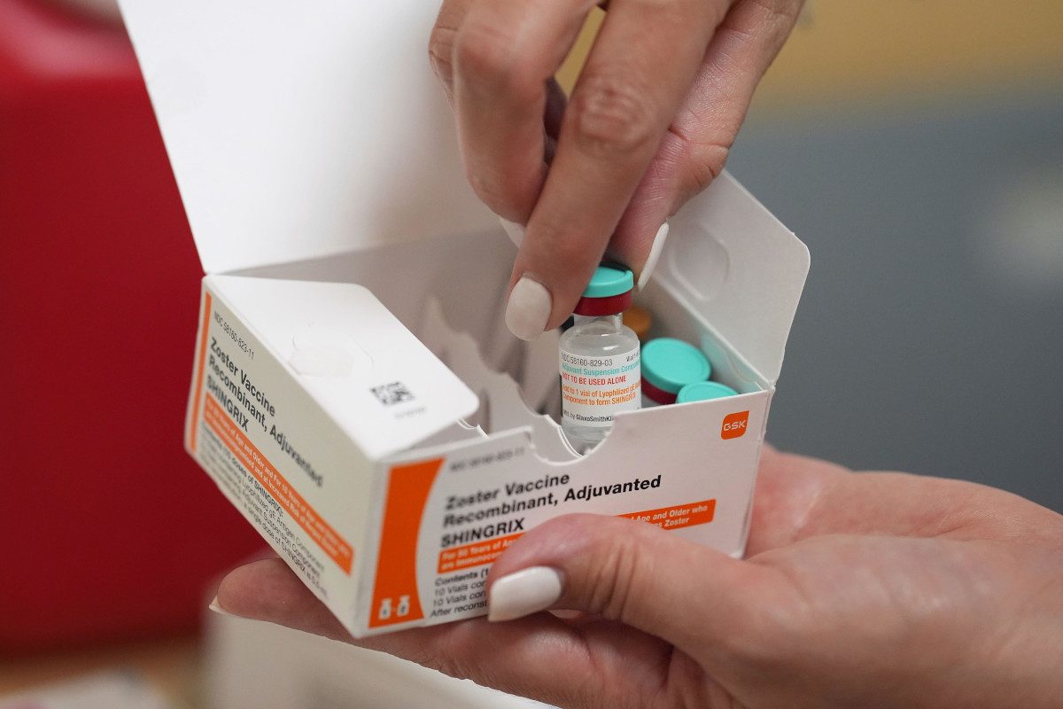 A pharmacist displays doses of a vaccine that protects against shingles
