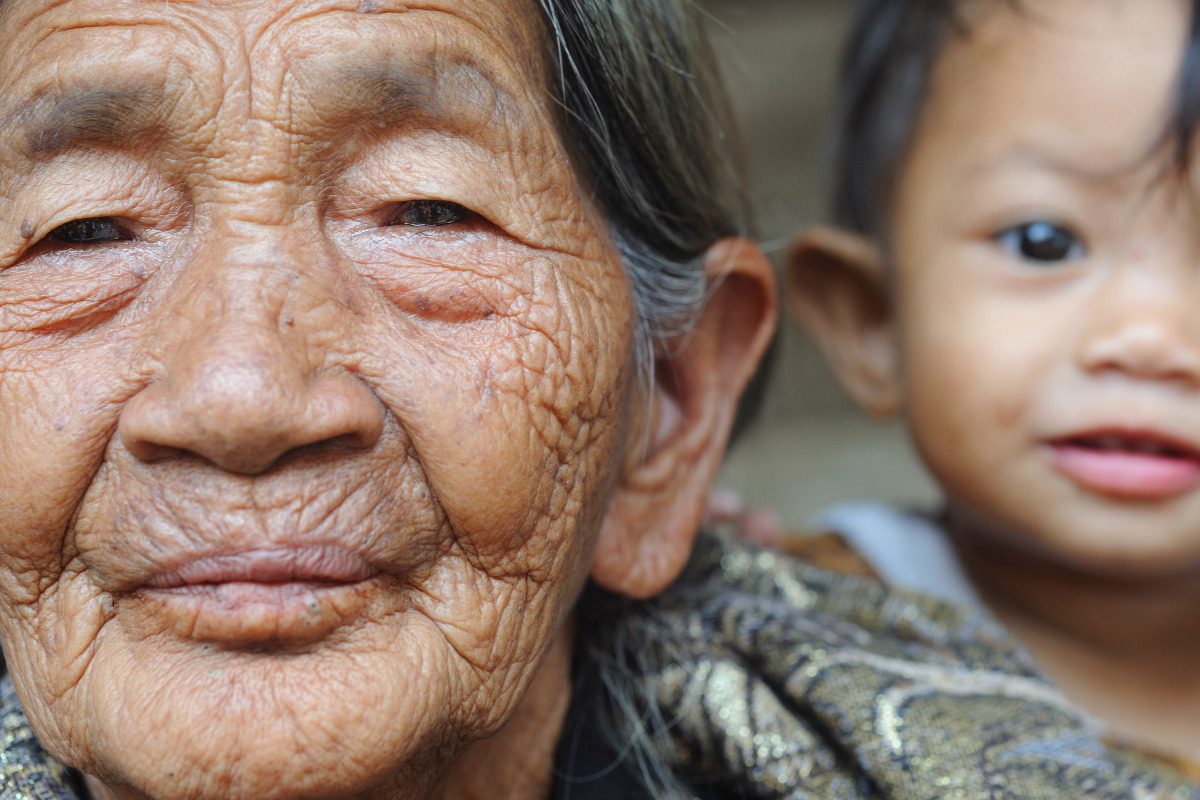 Photo of a grandparent and grandchild, the grandparent is in focus in the foreground