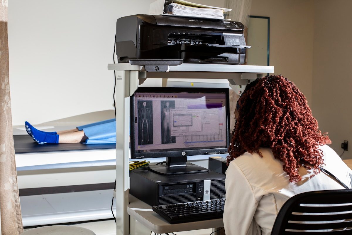 A technician using a dual energy x-ray absorptiometry