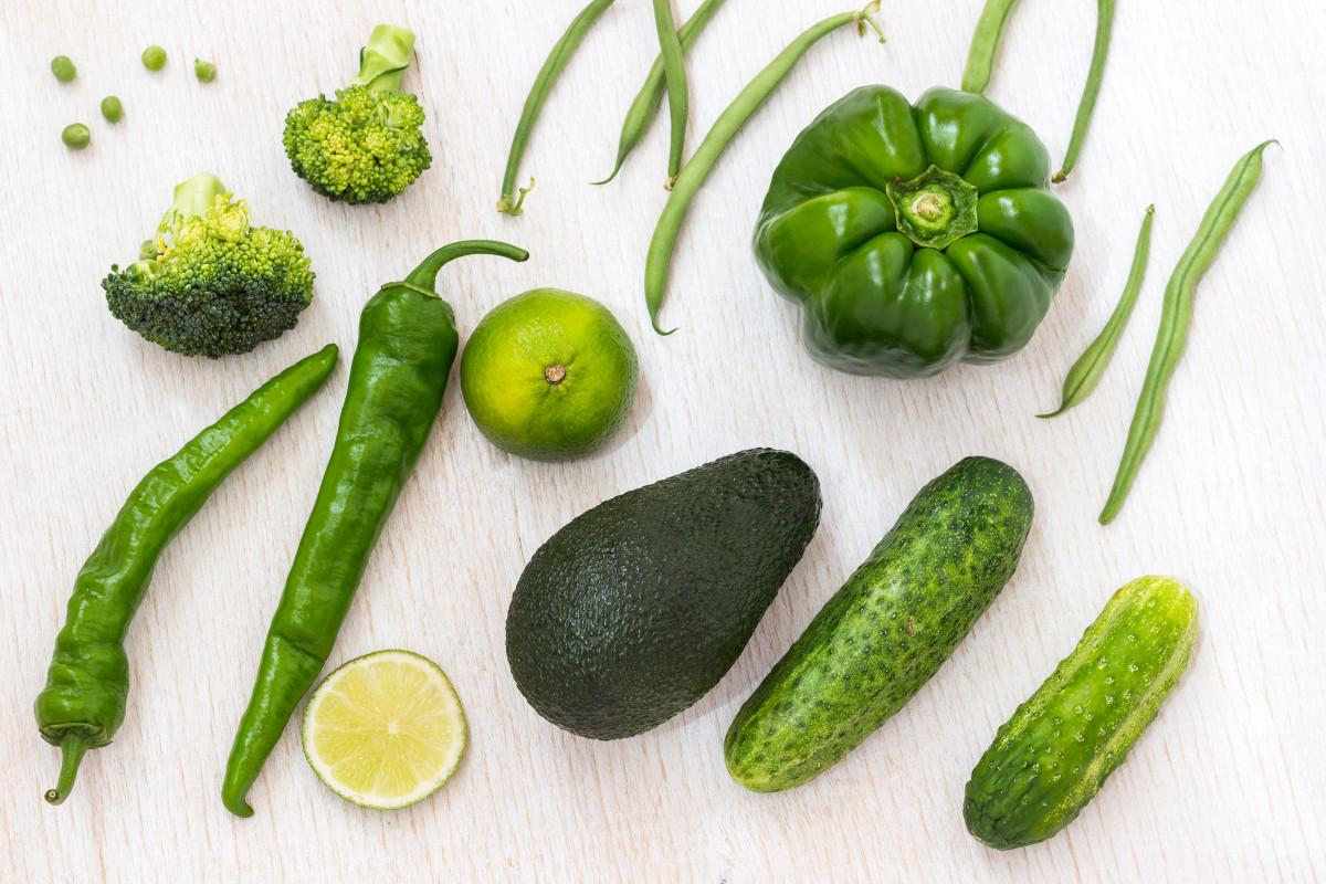 A set of green vegetables: asparagus, pepper, broccoli, avocado on a white background. Top view