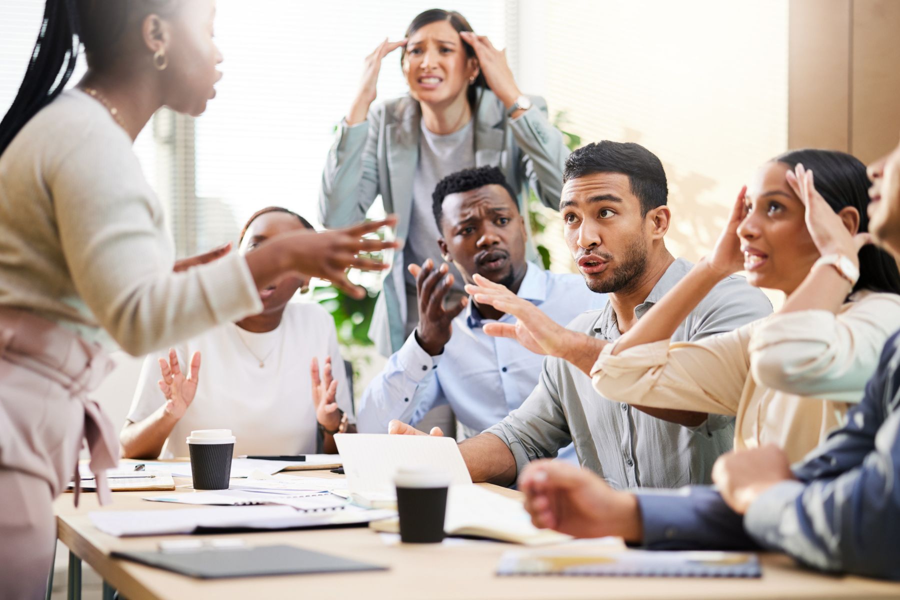 A group of colleagues argue intensely in a meeting room