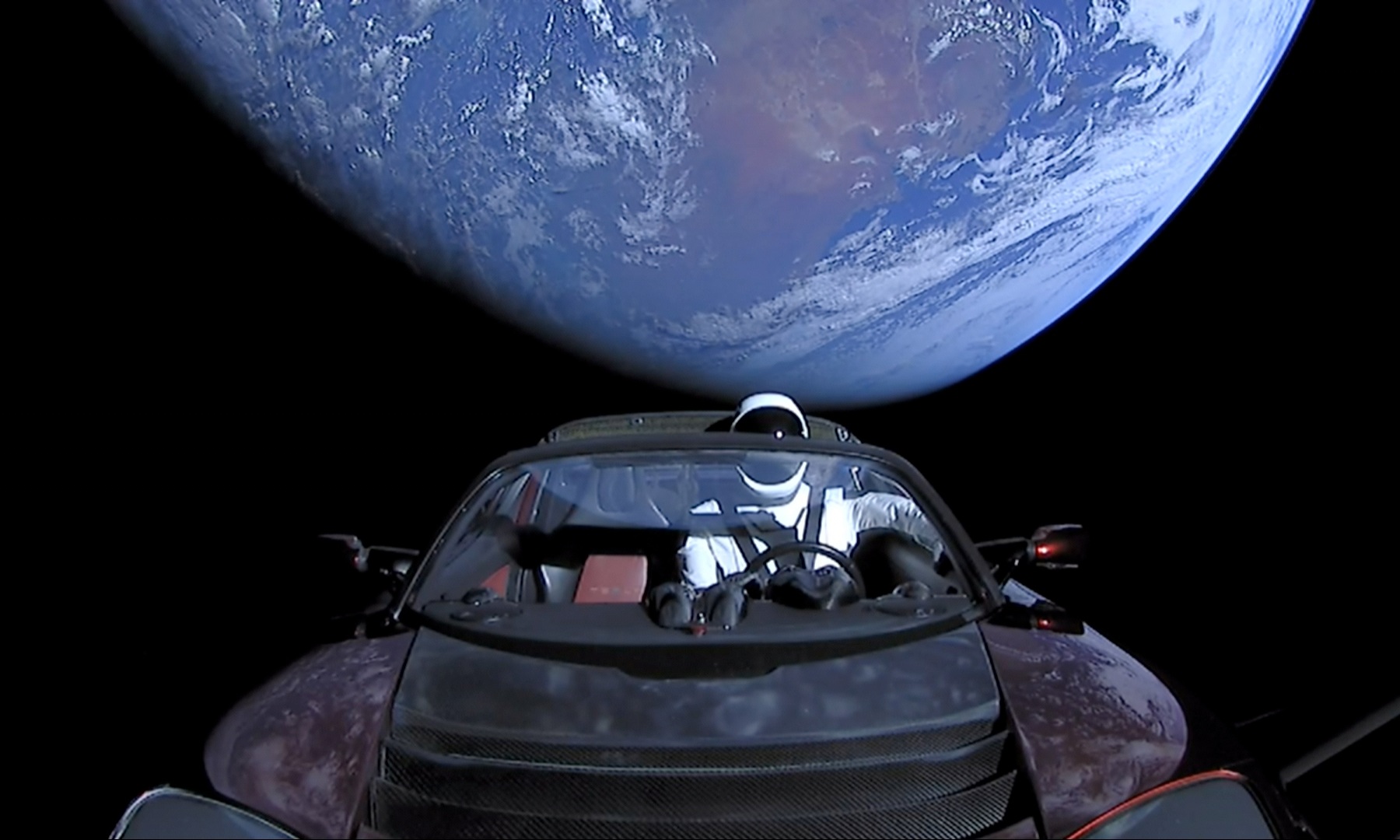 A roadster in space, with Earth in the background