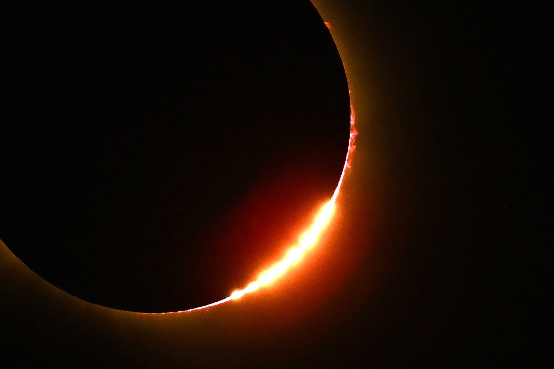 A bright patch of light glints at the side of a dark circle