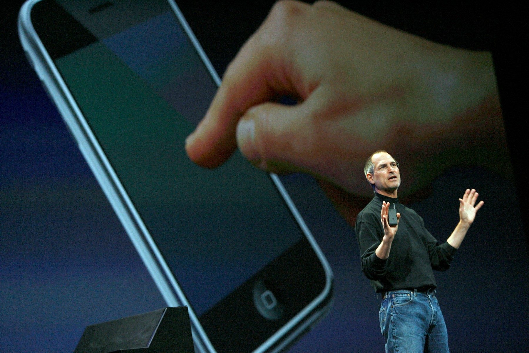 Steve Jobs in front of a giant iPhone