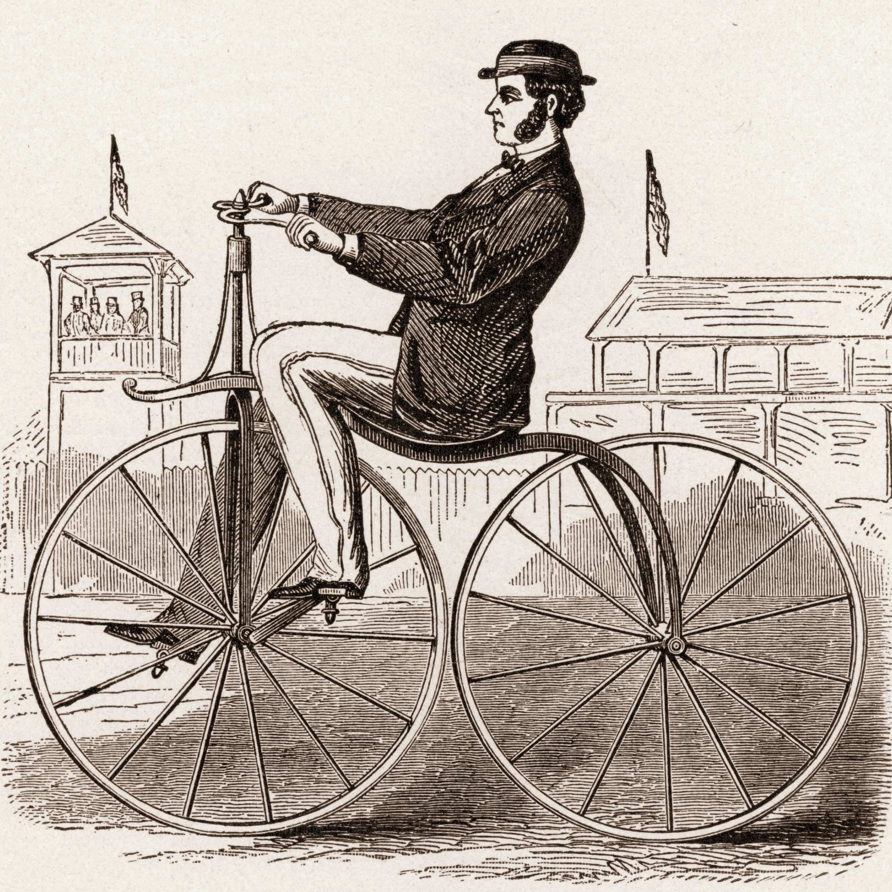 Man riding a velocipede with the pedals on the front wheel