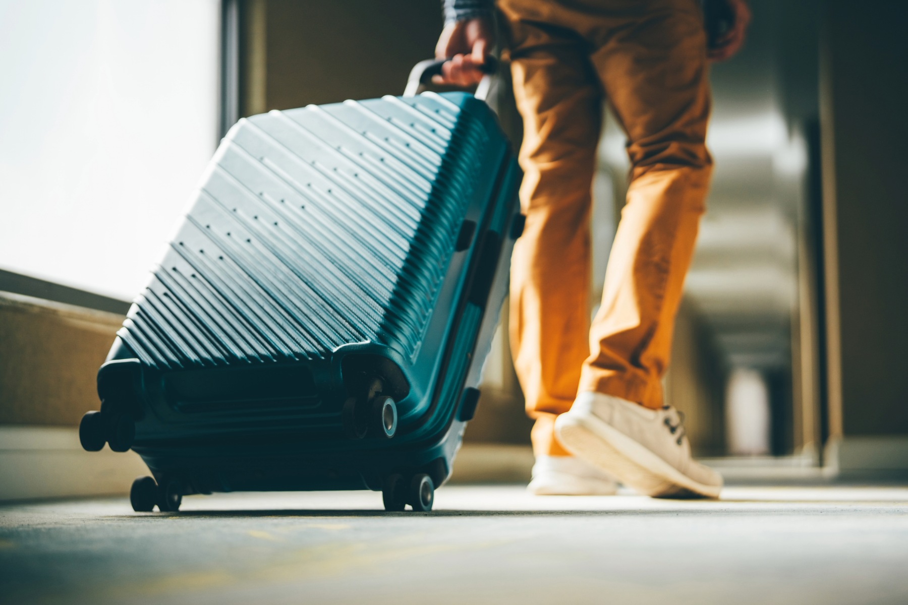 Person pulling wheeled suitcase