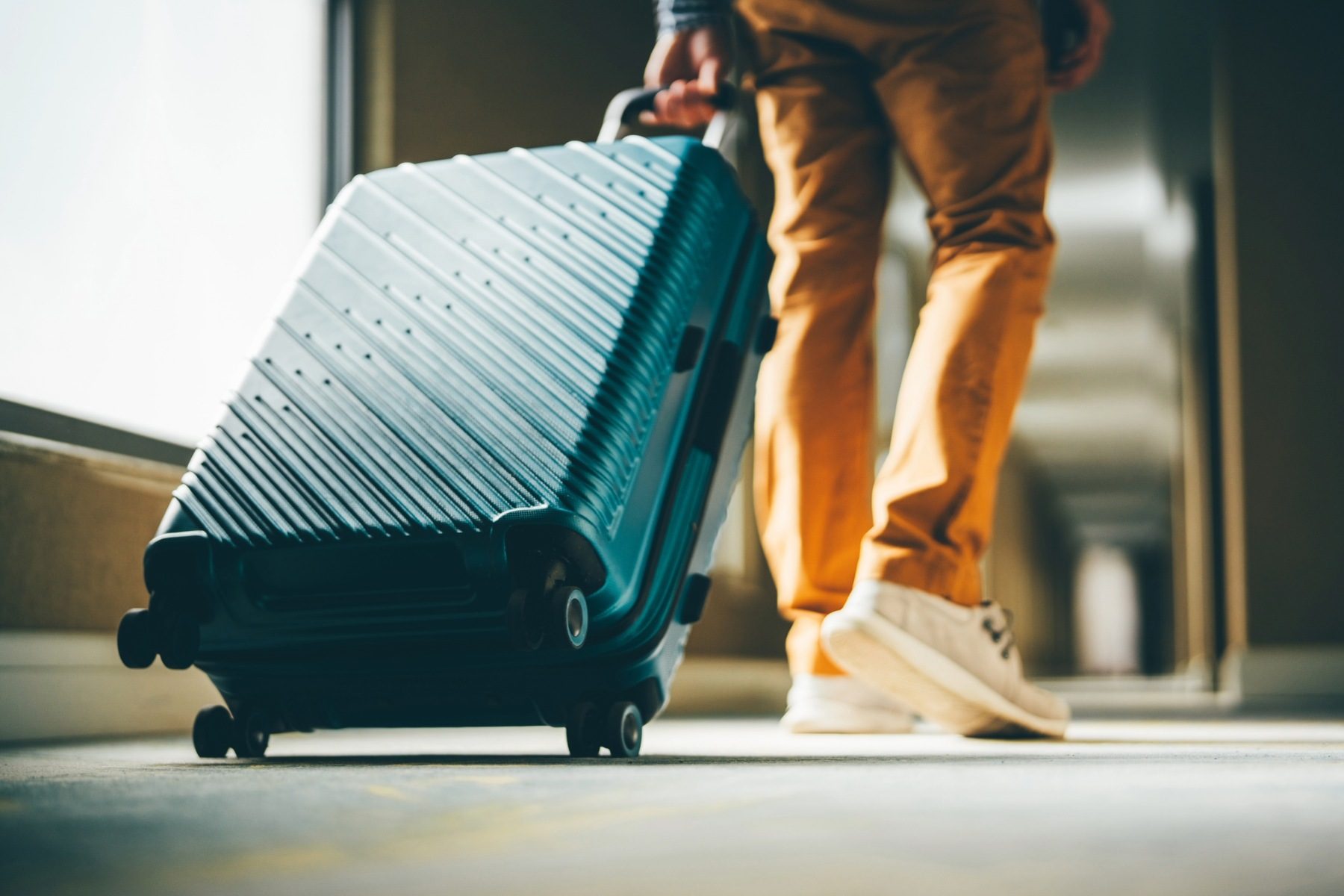 Person pulling wheeled suitcase