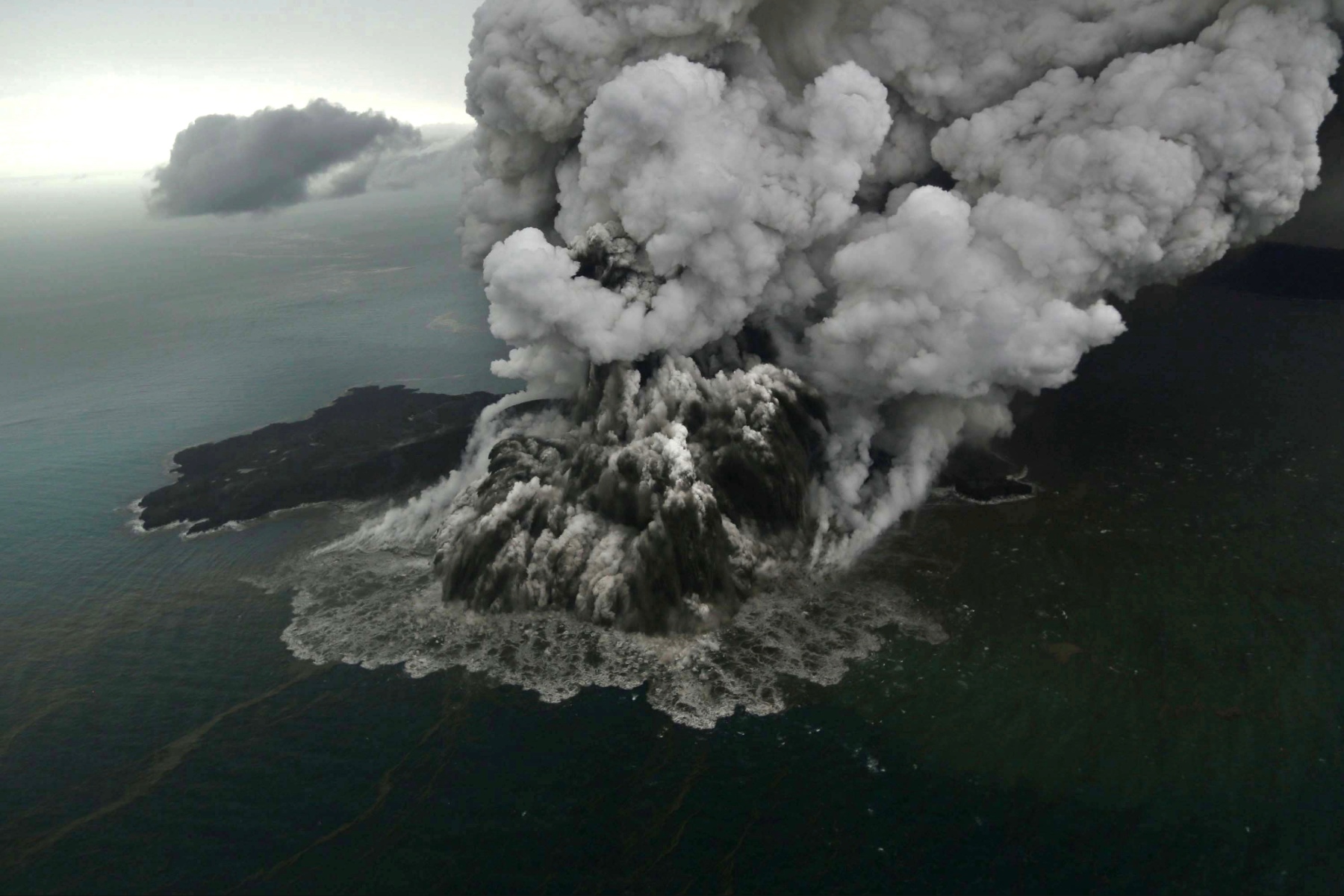 Coastal volcano erupting into the sea