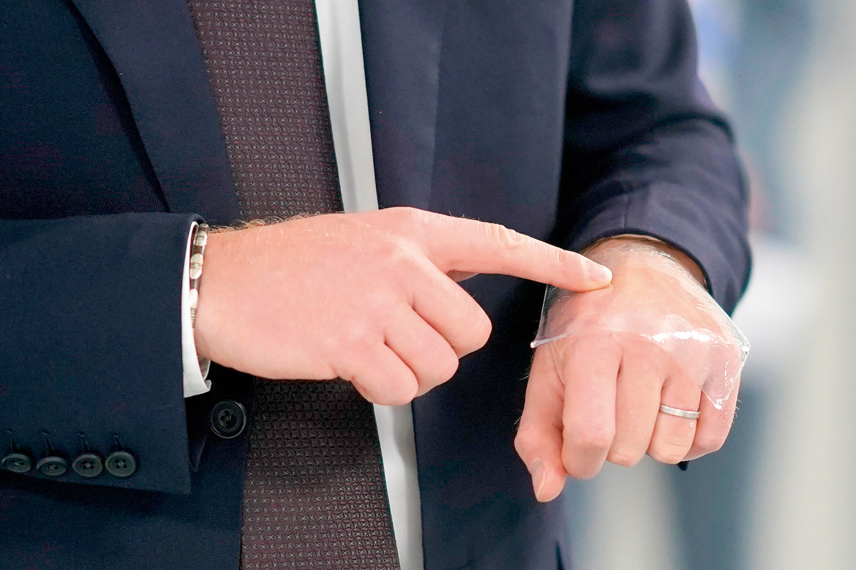 Close up of hands, one finger is pressing a clear dressing into the top of the other hand