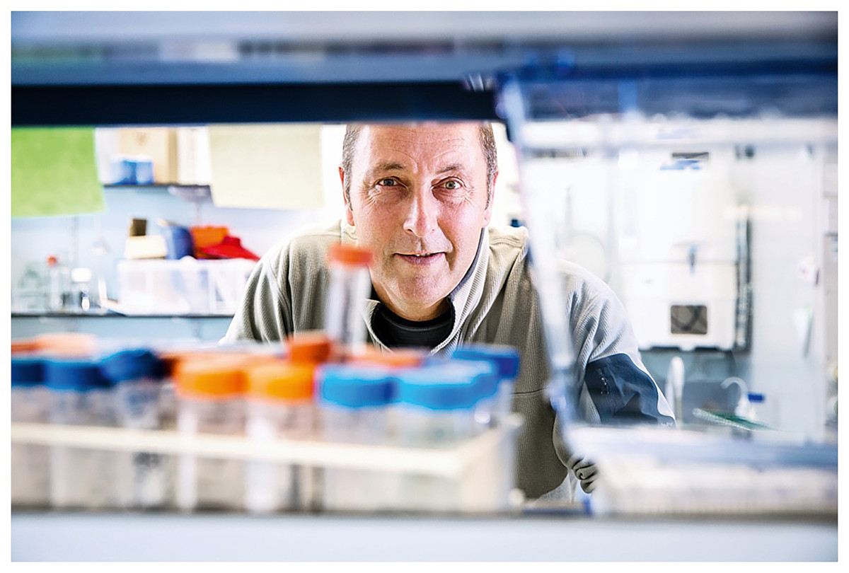 Photo of Prof Paul Martin looking at the camera behind various scientific vials