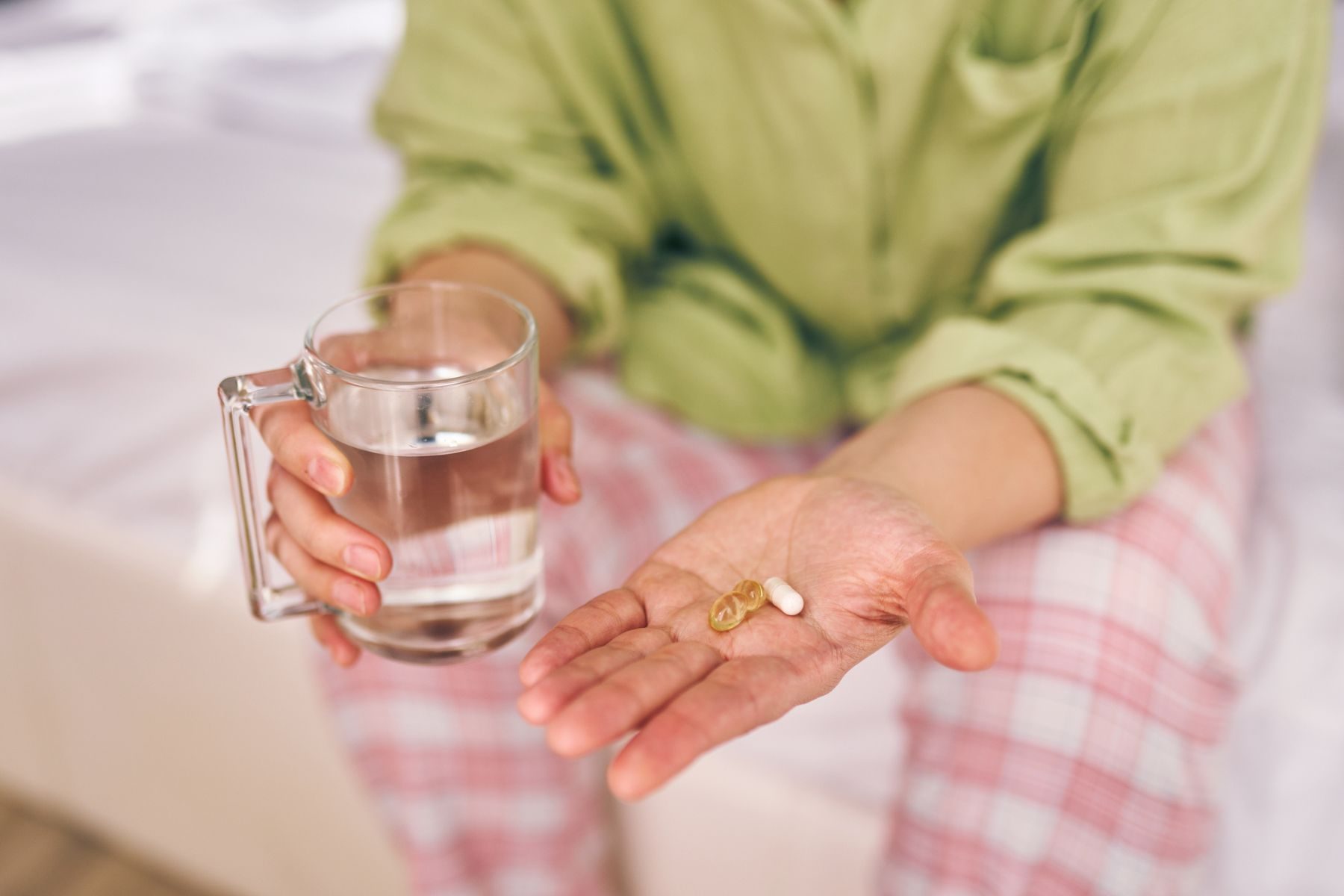 10 Expert-Approved Surprising Facts About Orgasms You Didn't Know 4 An adult holds pills and water