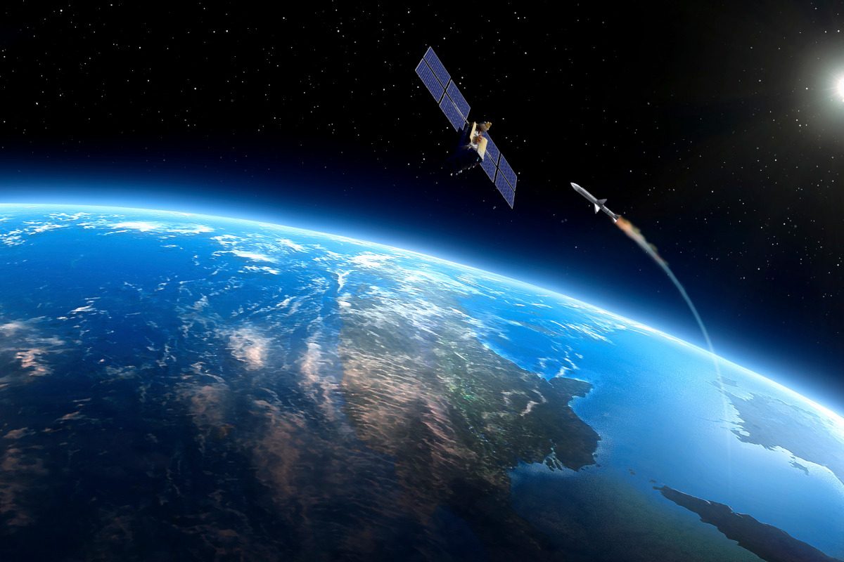 Artwork depicting space warfare. A missile, launched from a ground station, is seen approaching a satellite in orbit above the Earth.