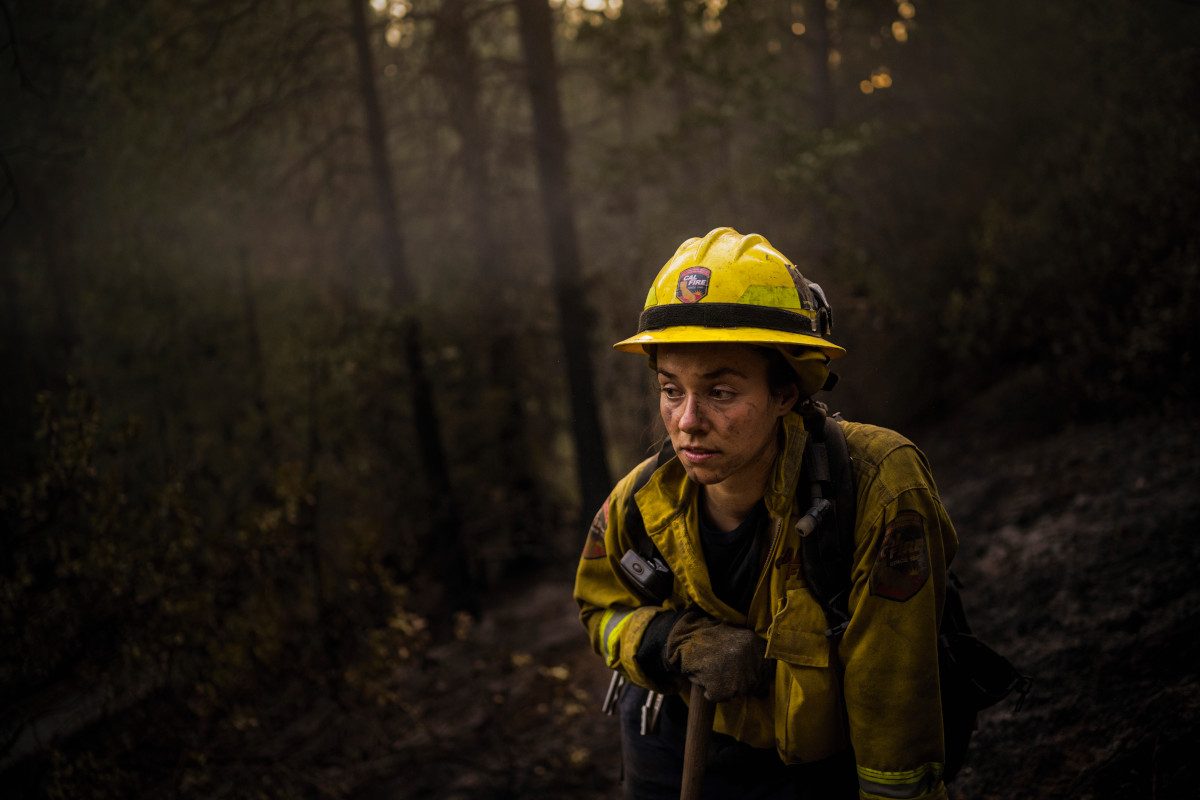 A firefighter cleaning up the destruction caused by the 2021 Dixie Fire in California
