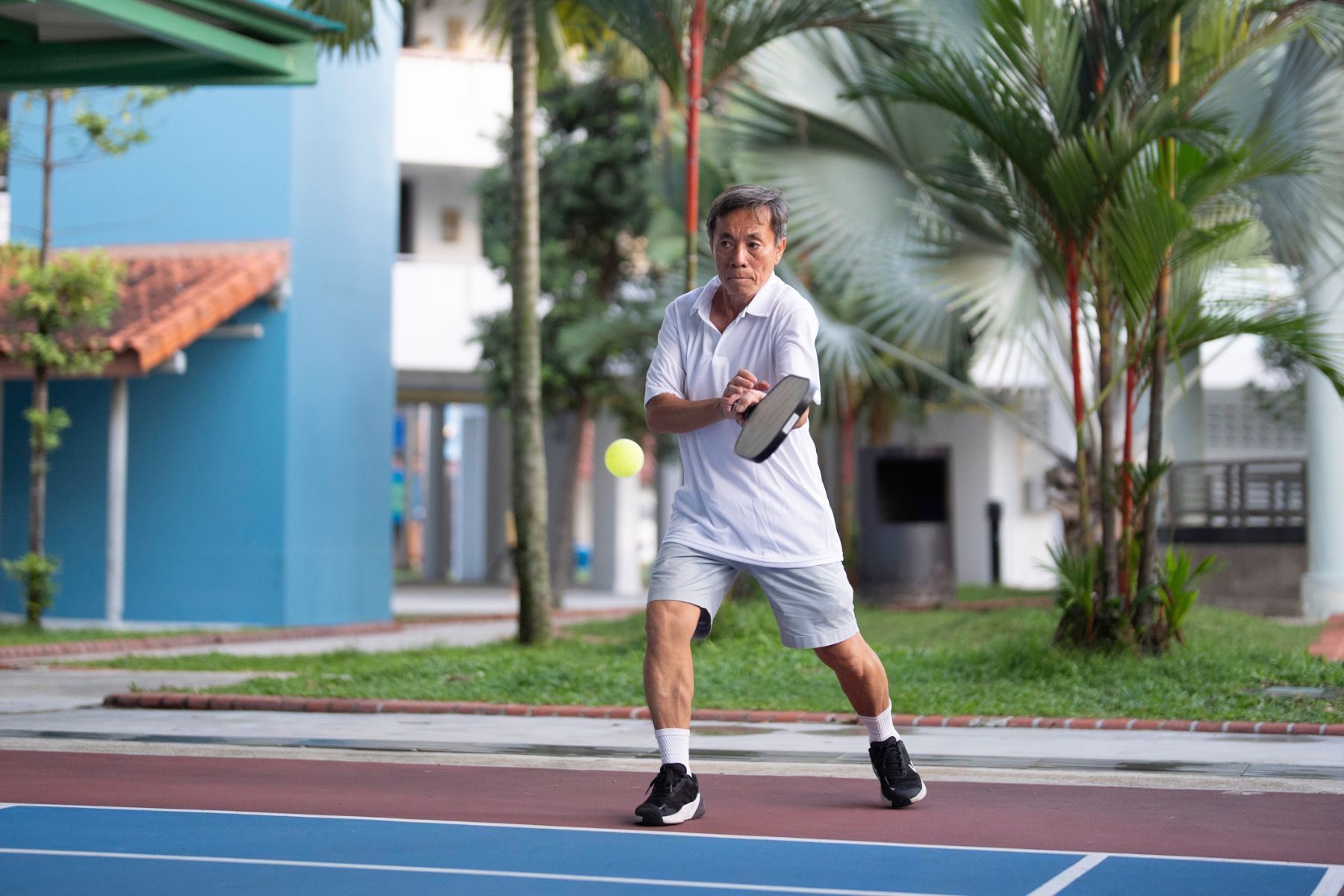 Man in Singapore playing pickleball on a public court
