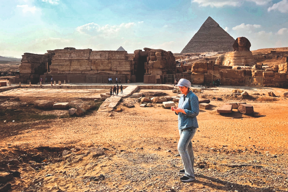 Prof Enam Ghoneim standing on the Giza Plateau in Egypt with the Great Sphinx & Pyramids in the background