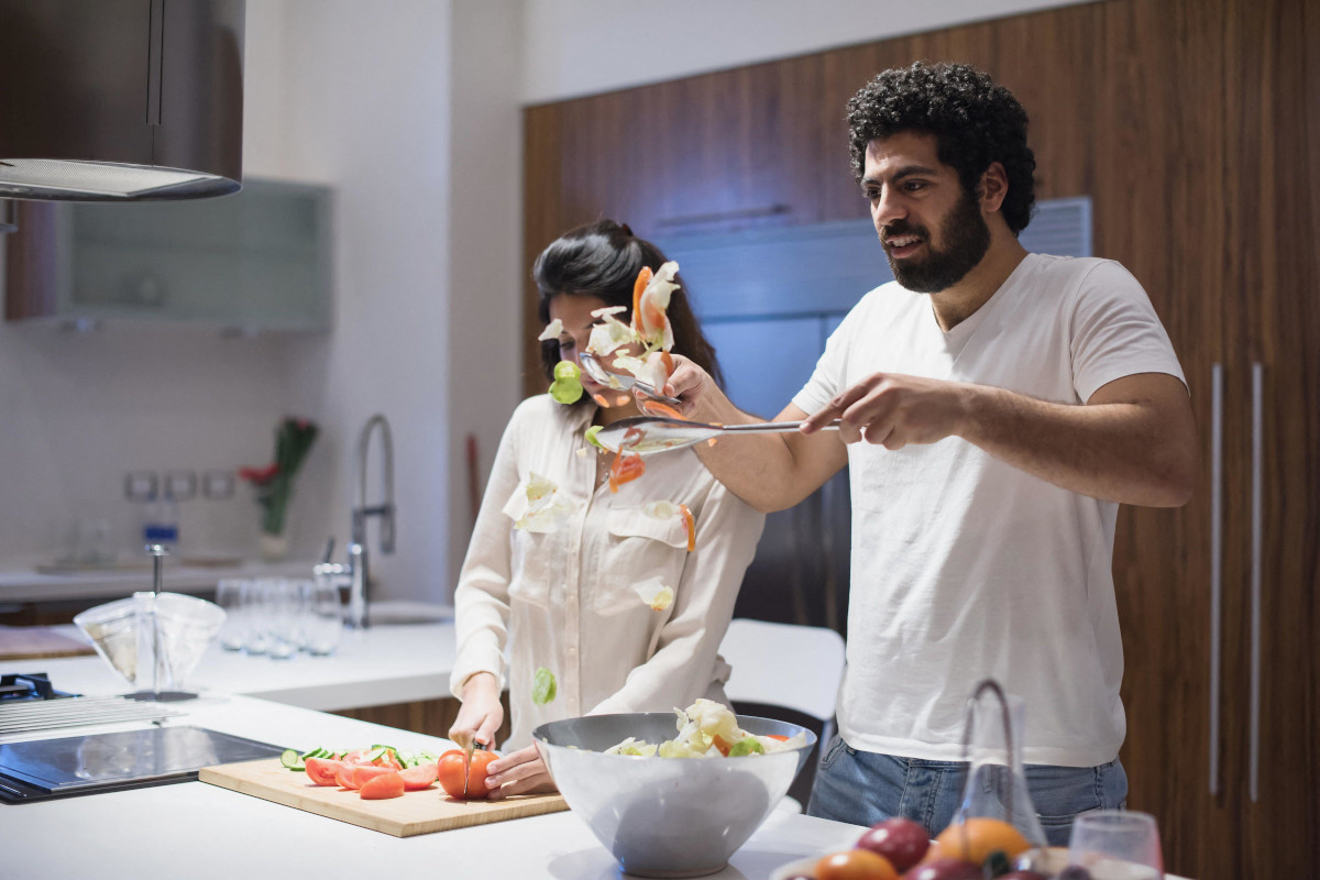 A happy couple preparing a salad together