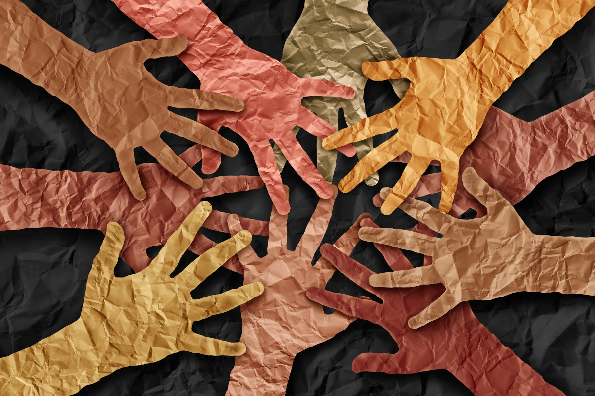 Paper cutouts showing a community of hands coming together joining a diversity collaboration