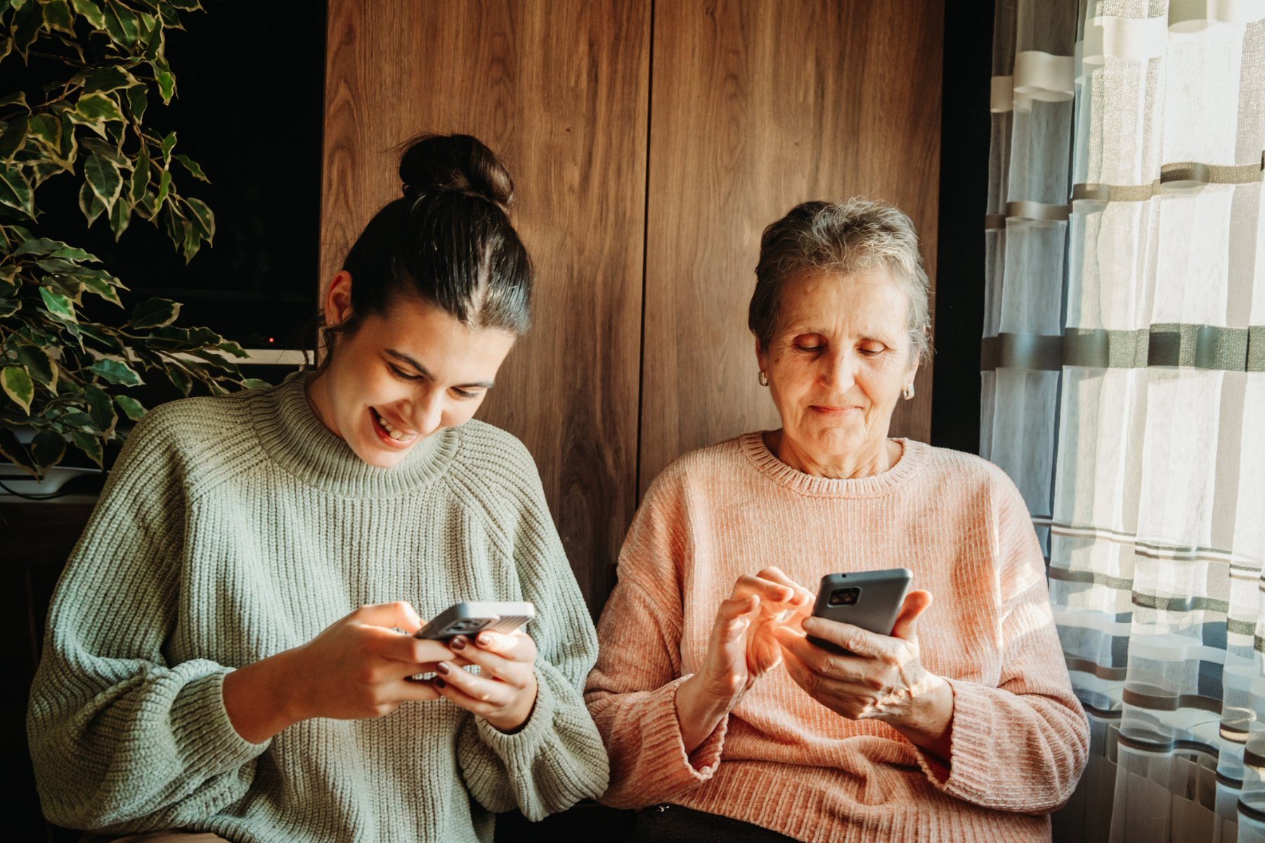 Senior and young woman on smartphones