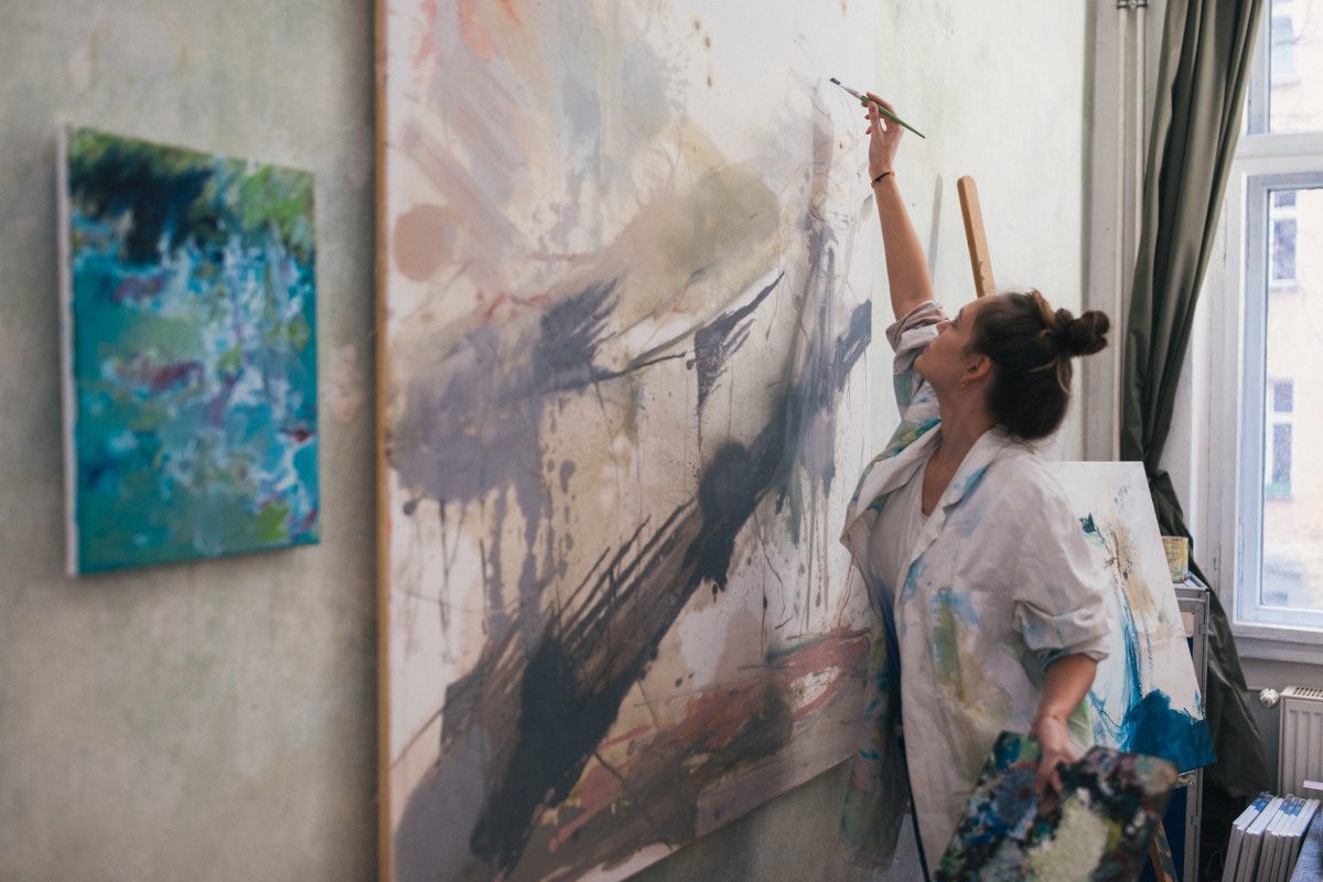 Woman painting in artist studio, a big oil painting